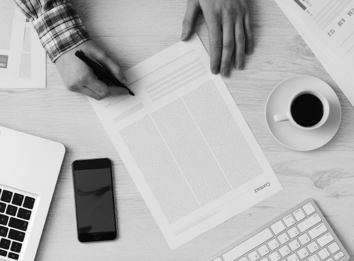 man zet handtekening op een document